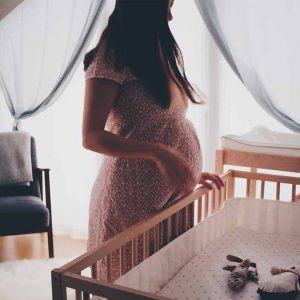 Pregnant woman by a crib