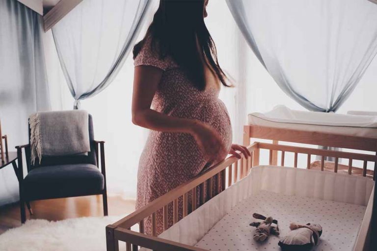 Pregnant woman by a crib